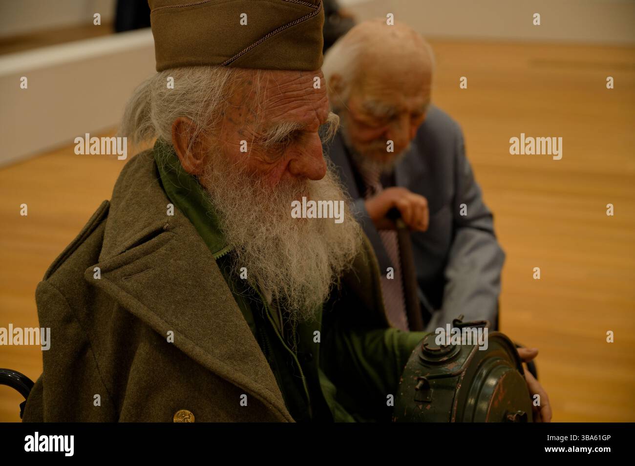 Two hyperrealistic elderly figures sit in wheelchairs, part of 'Old Persons Home' displayed at the M+ Museum Stock Photo