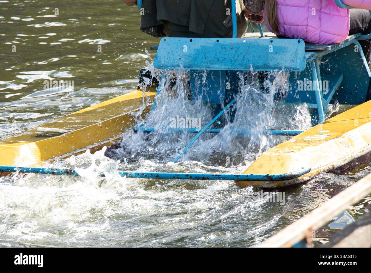 Catamaran with people floating near the pier on the Dnieper River in spring in Ukraine, old river catamaran on the river Stock Photo