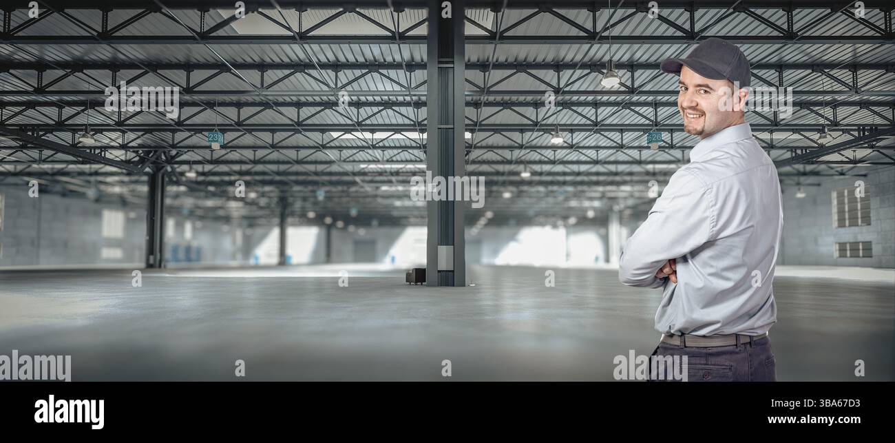 Supervisor smiling with crossed arms in empty warehouse Stock Photo