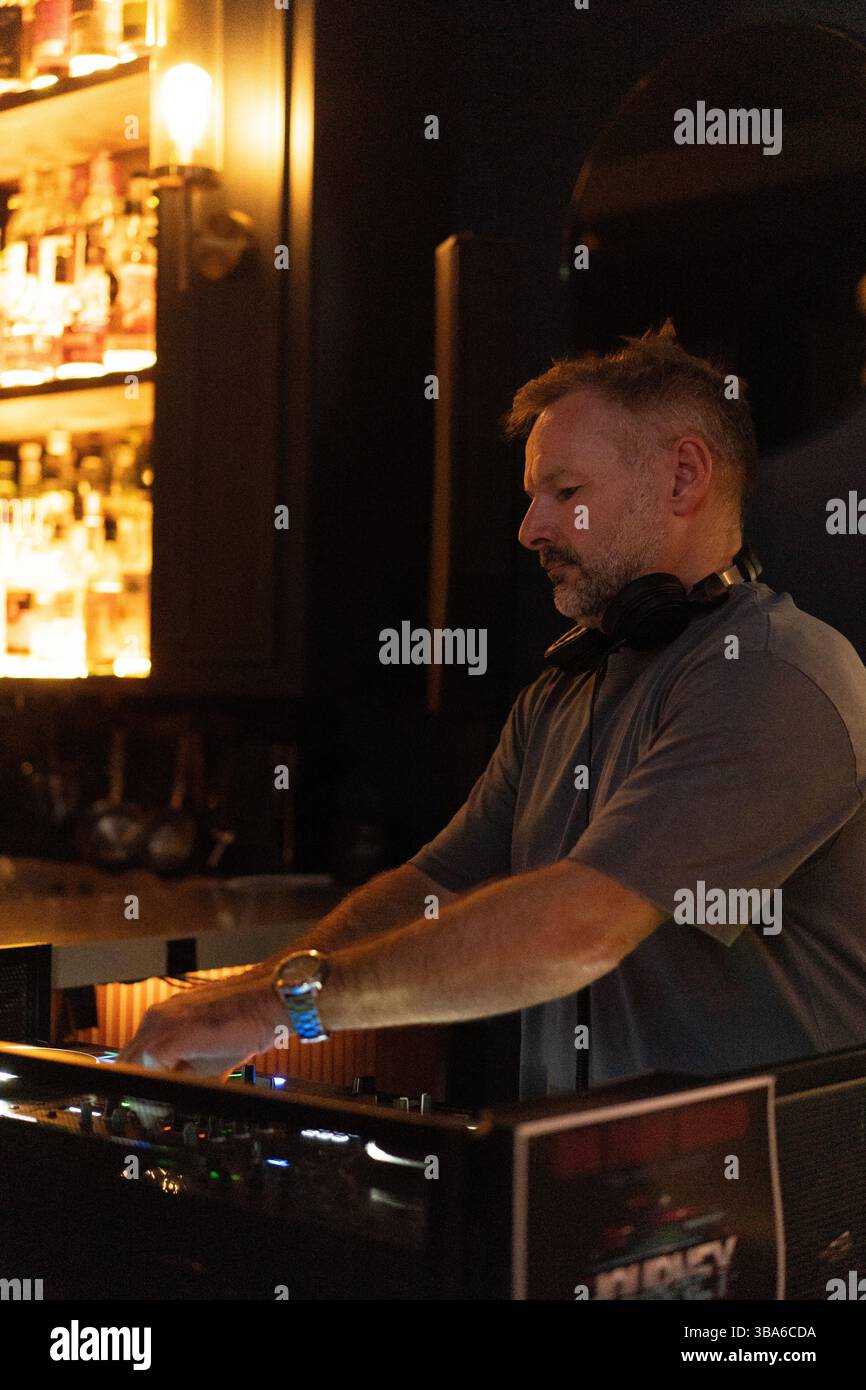 DJ amidst friends enjoying at nightclub Stock Photo