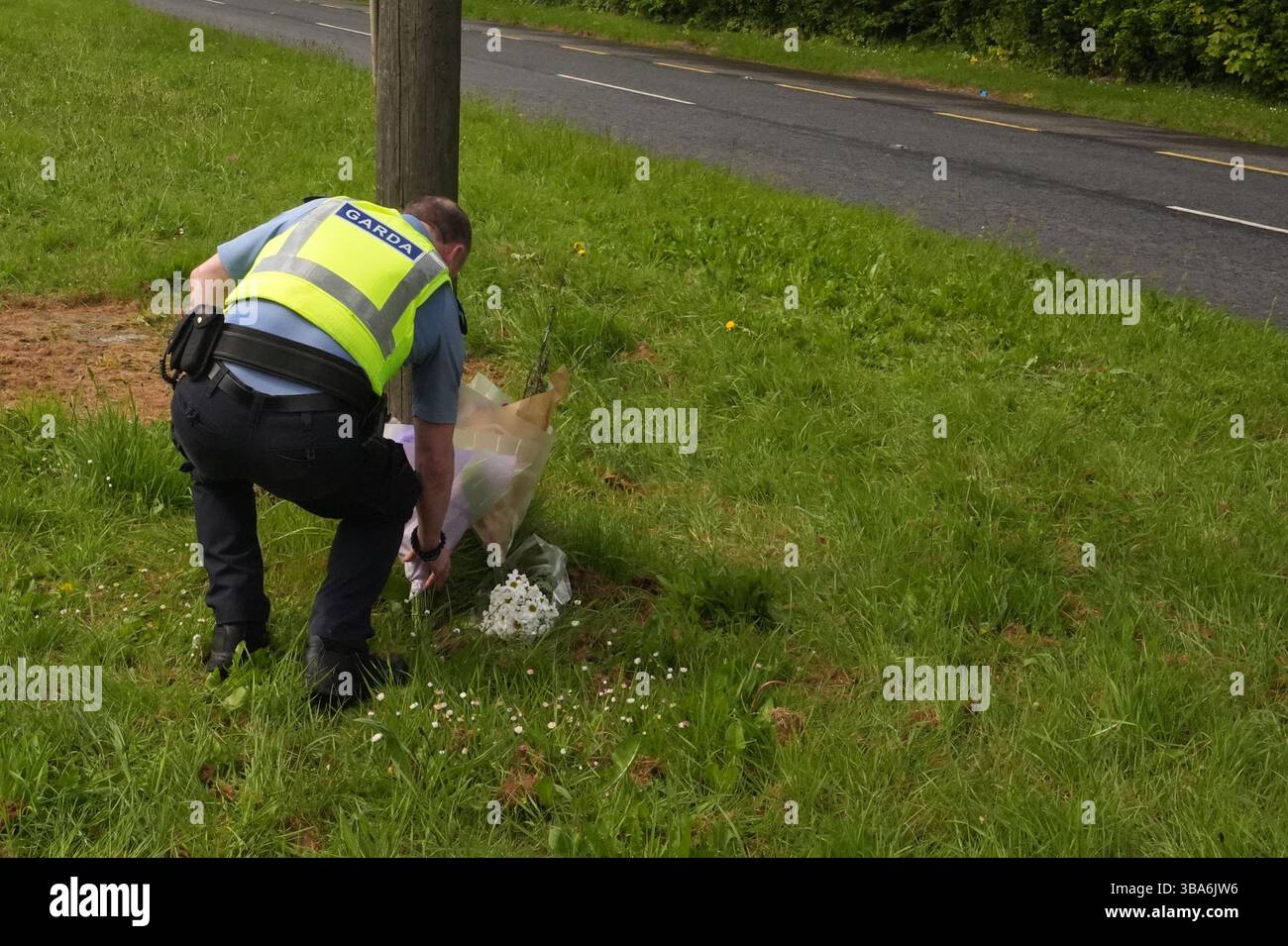 A garda officer leaves flowers near to the scene where An Garda ...