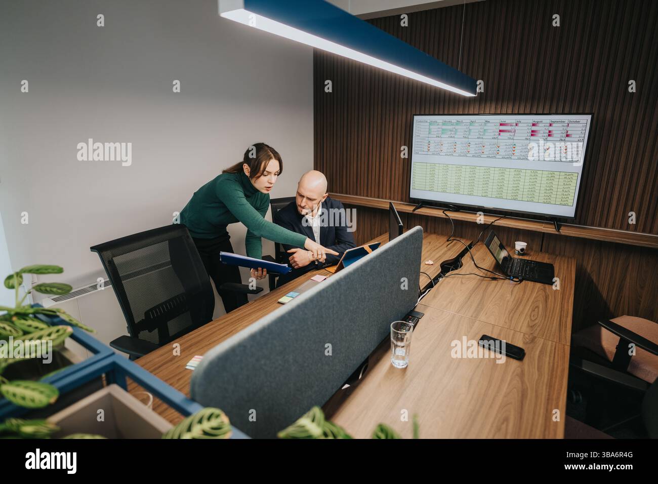 Business colleagues analyzing data collaboratively in a modern office environment Stock Photo