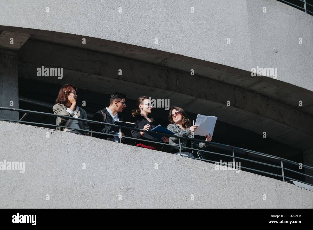 Multicultural business team analyzing data on office balcony Stock Photo