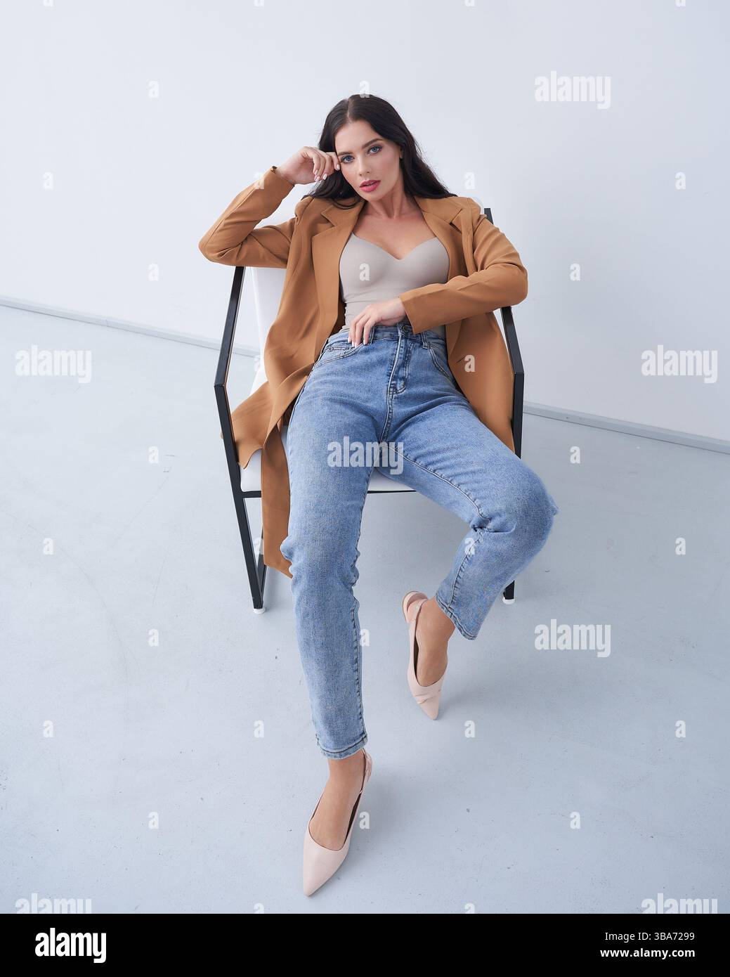 Elegant model poses in a stylish outfit inside a modern studio setting ...
