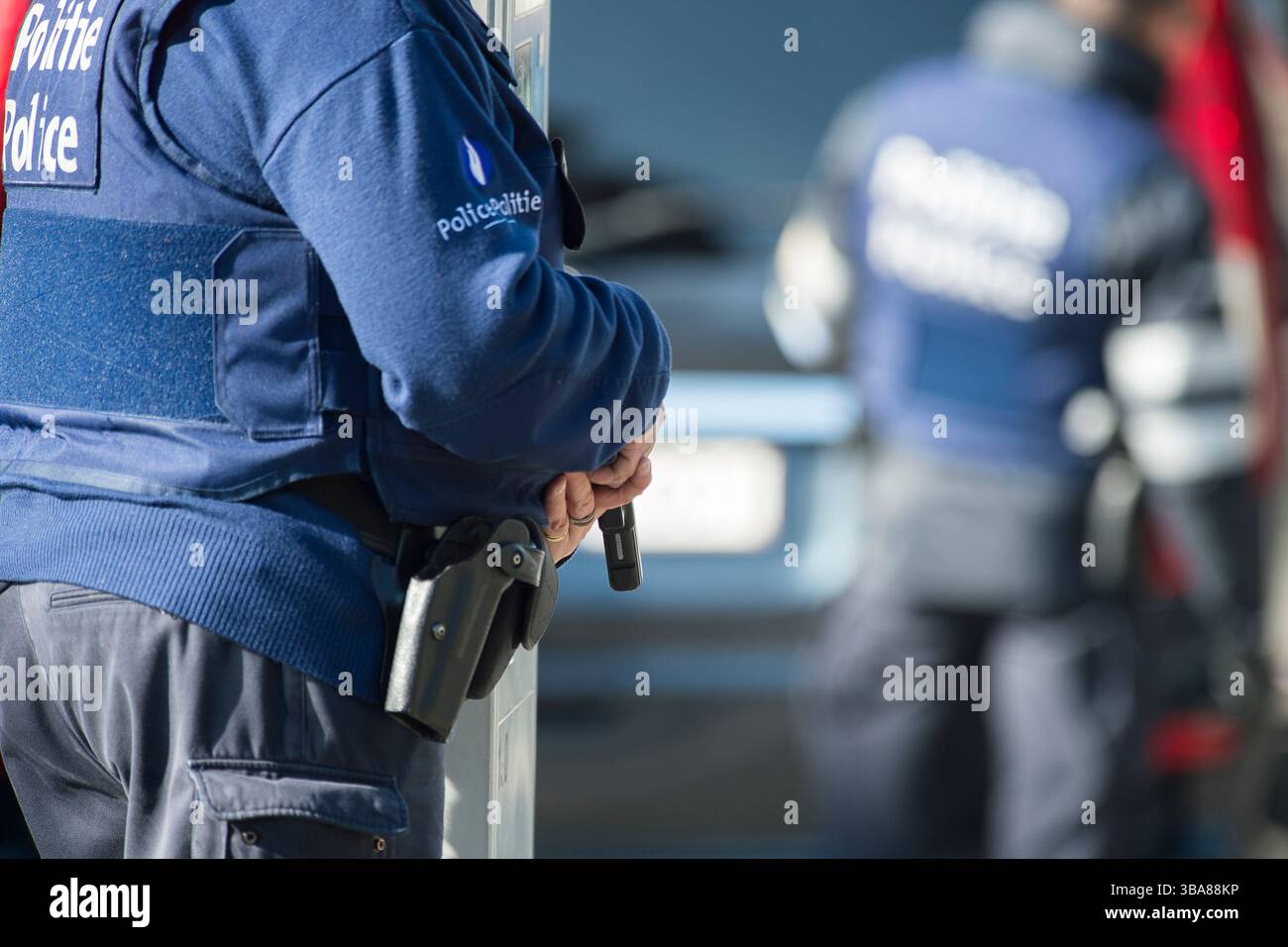 Déploiement de forces policieres a proximite de la place Saint-Denis a Forest. le policier tient son arme de poing à la main | Police deployed near Pl Stock Photo