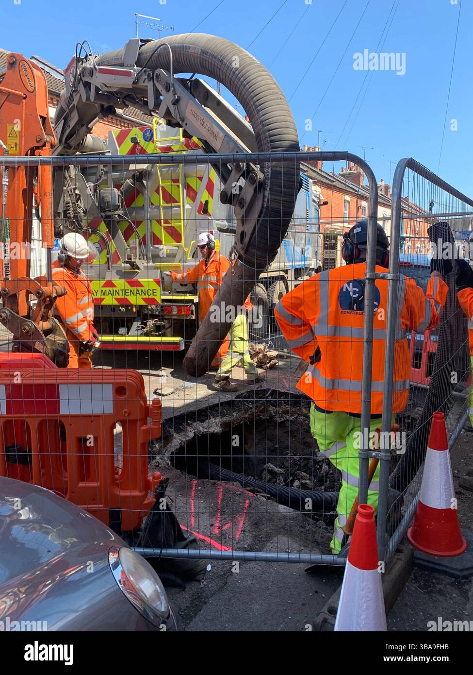 Waste gas dig dug digging lorry mend repair explosion street close closed men work working outside helmets helmet engineers bollards bollard house UK - Smartphone Captured Stock Image