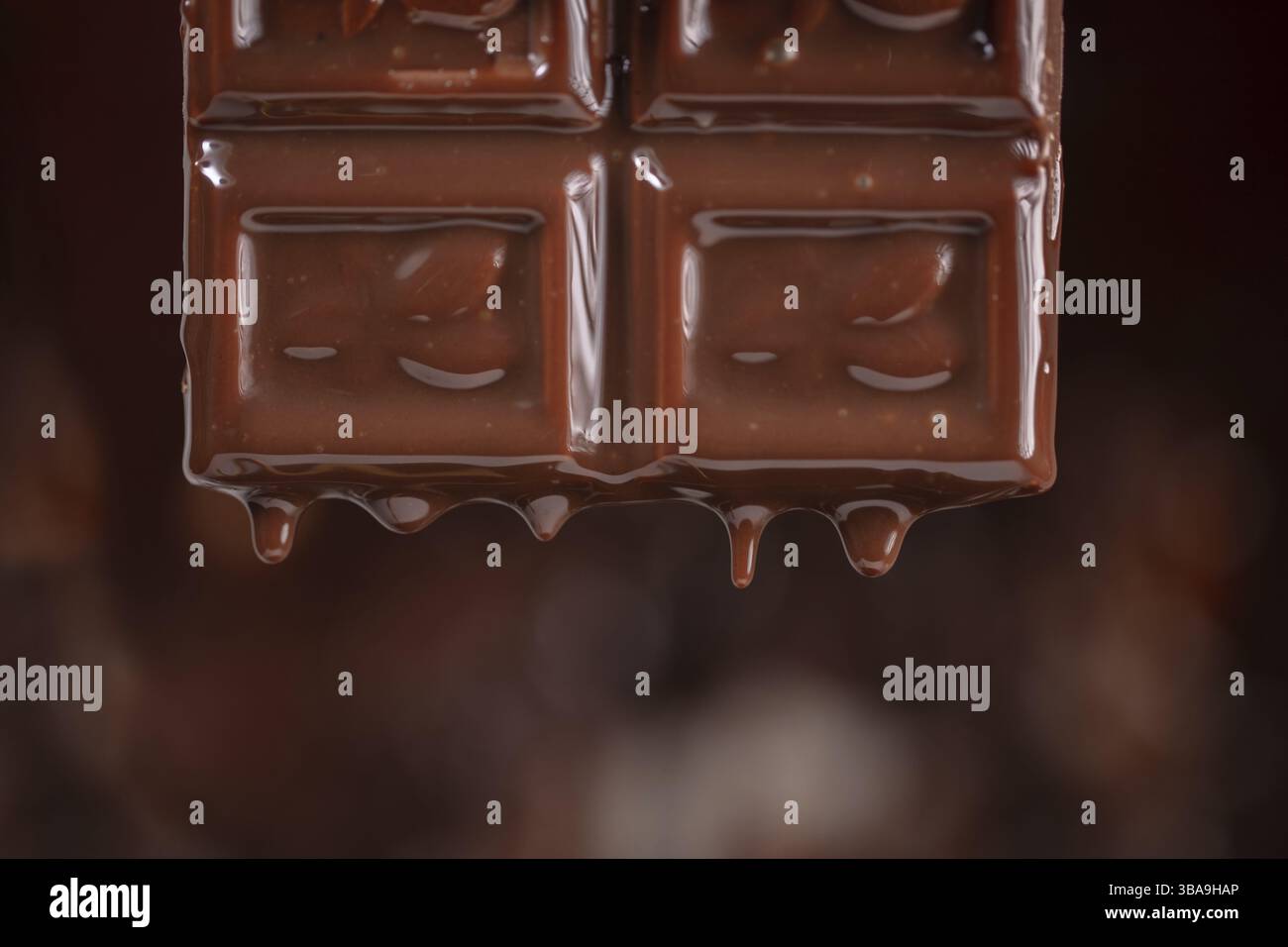 Melted chocolate drips down on a brown background Stock Photo