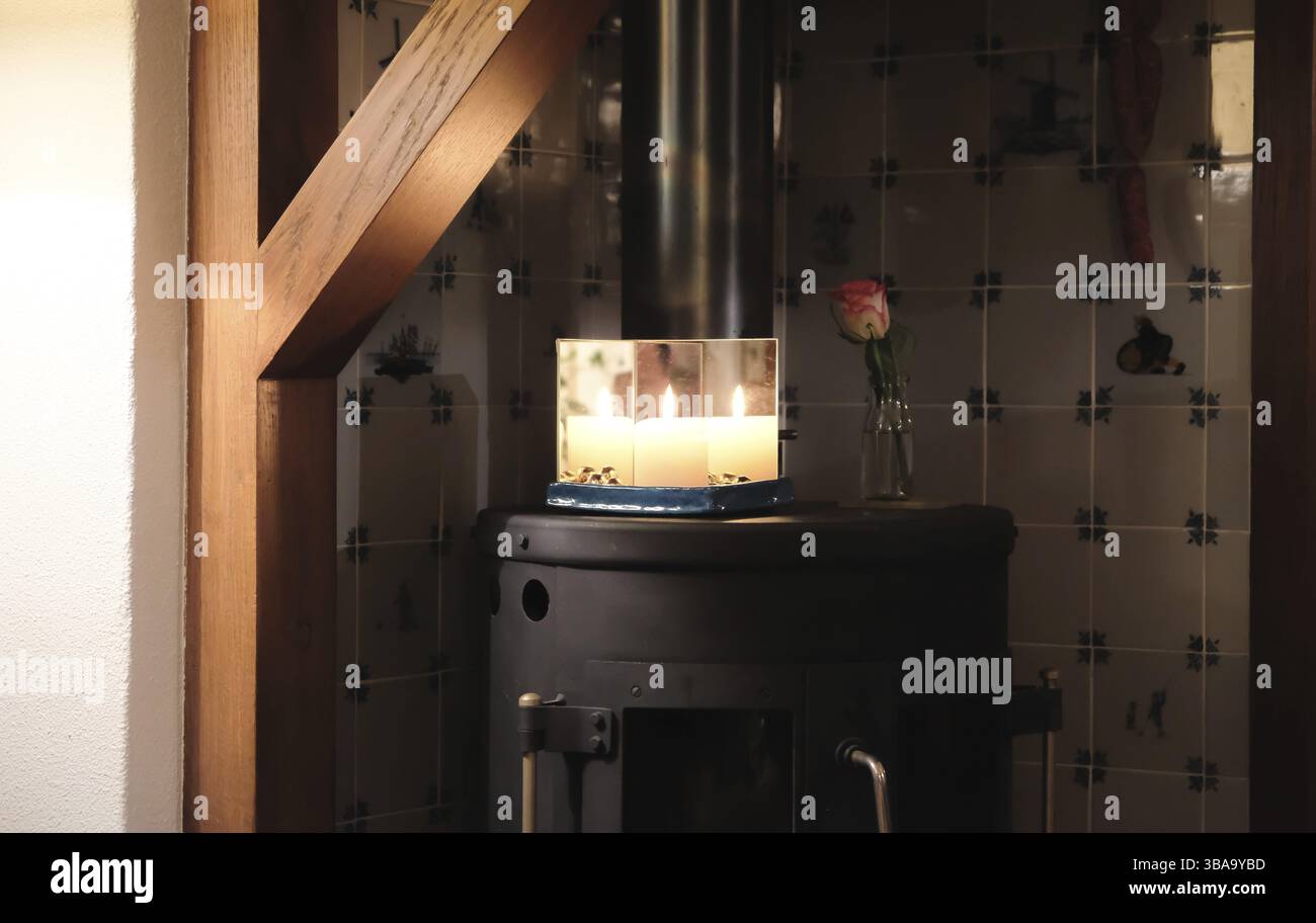 Christmas candle between mirrors on a stove Stock Photo