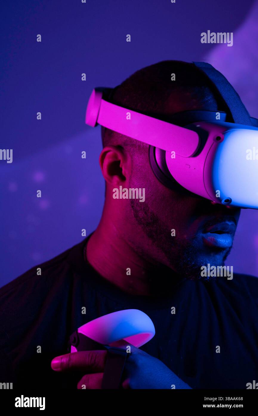 Serious Black man wearing VR headset experiencing virtual reality ...
