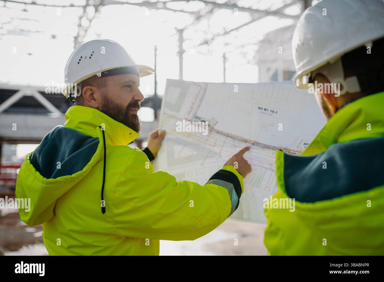 Construction managers using digital tablet on site, reviewing project plans. Stock Photo