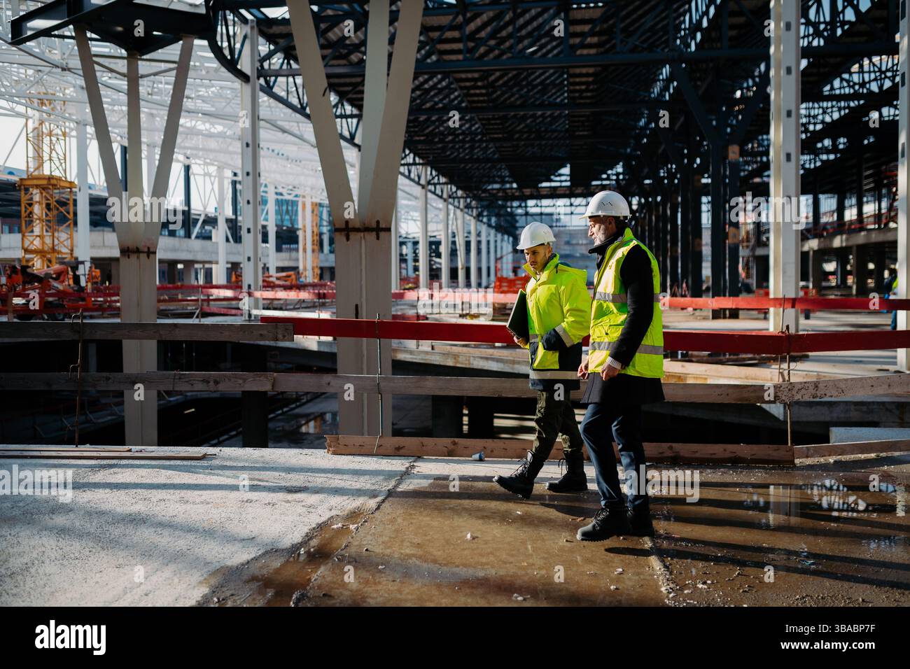 Construction managers using digital tablet on site, reviewing project plans. Stock Photo