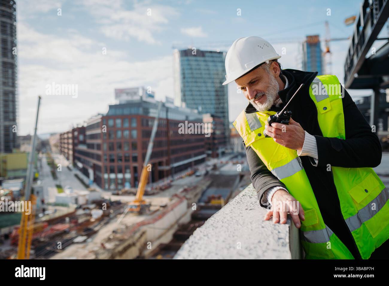 Site manager giving instructions over radio during building inspection ...