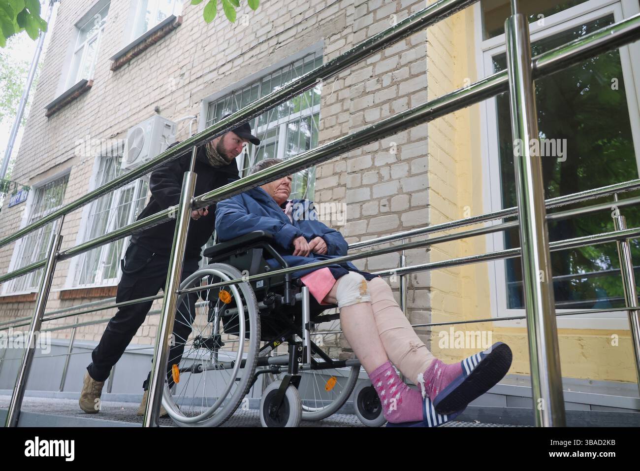 Evac Ramp Non Exclusive: A volunteer pushes the wheelchair of an elderly woman up ...
