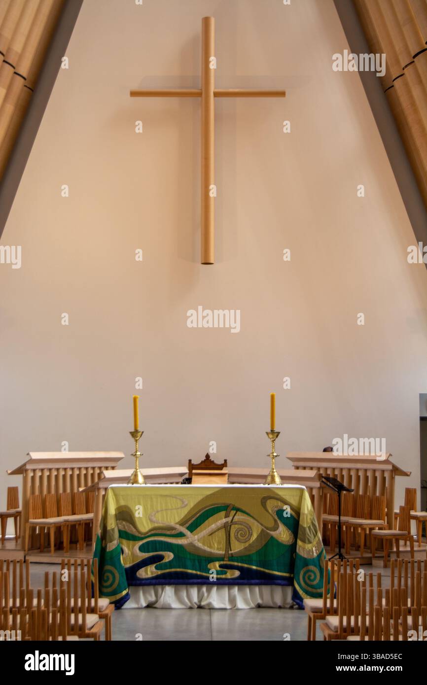 A serene interior of a church featuring a large wooden cross on the ...