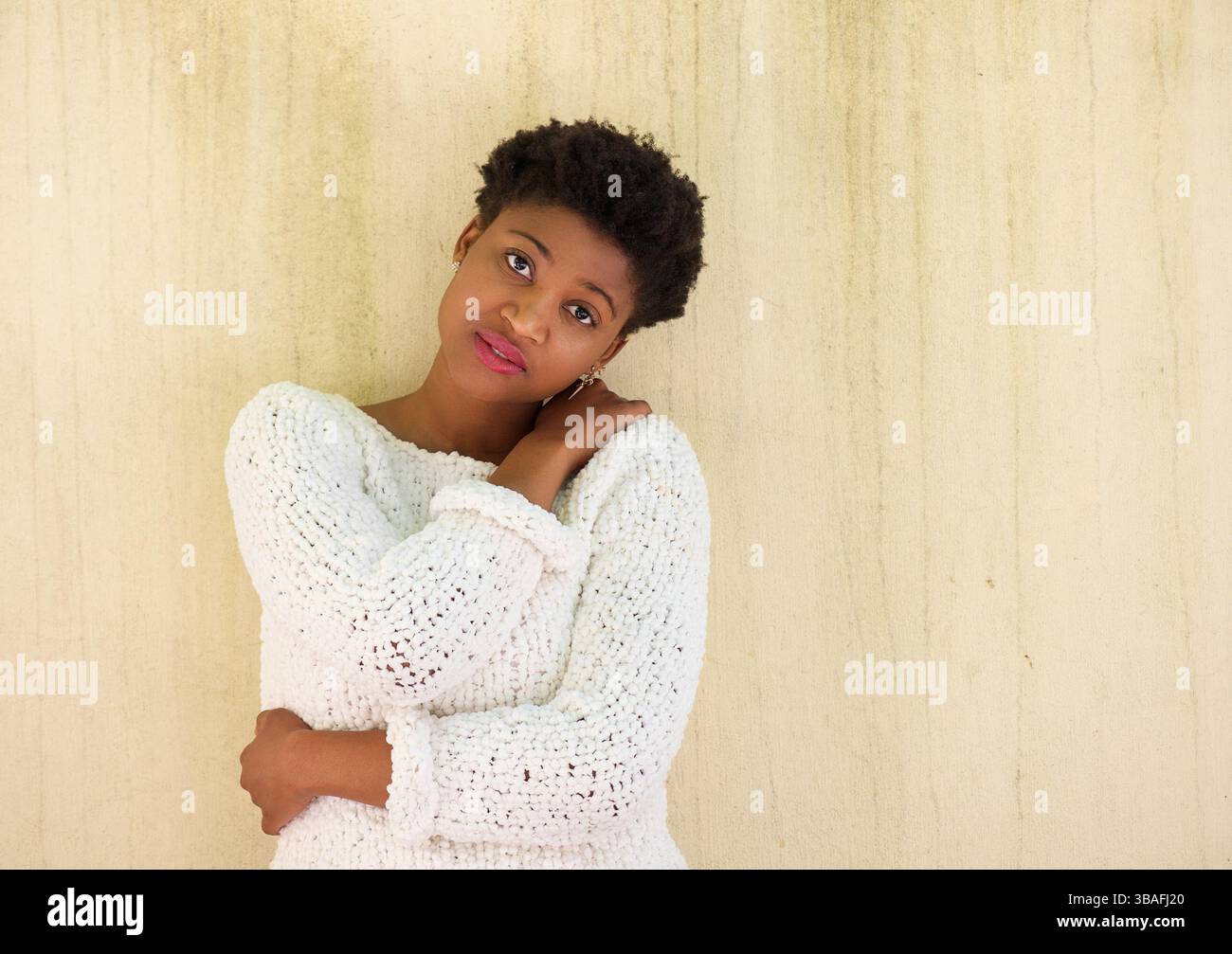 Portrait of a young african american woman standing alone with arms ...