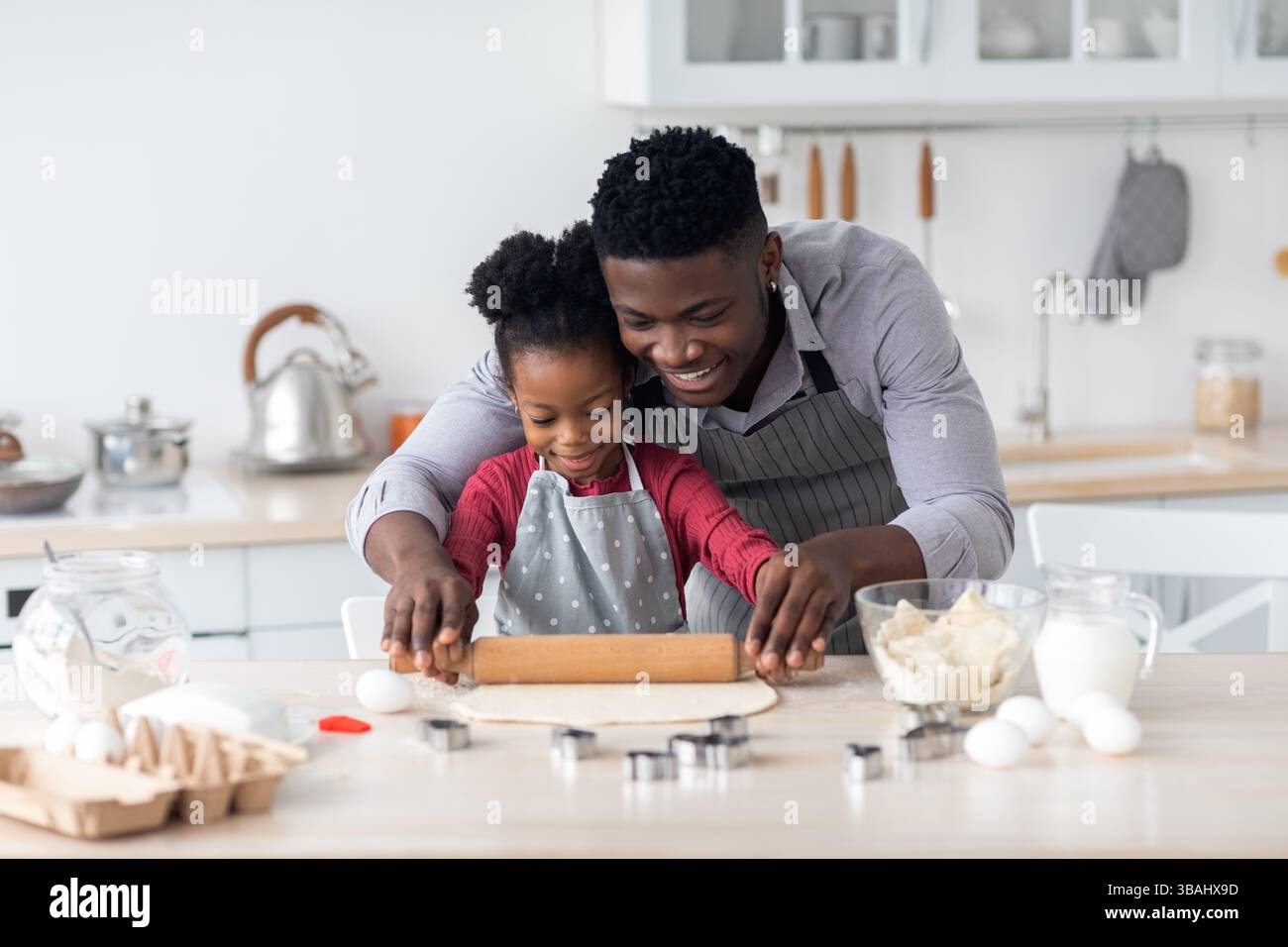 Loving single black father making cookies with little daughter at home ...