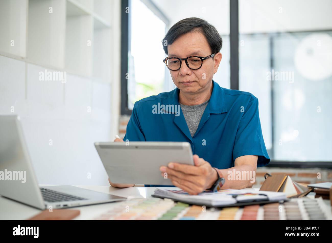 A professional senior Asian male interior designer is designing the ...