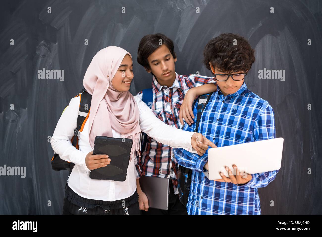 Arabic teenagers team, students group working together on laptop and ...