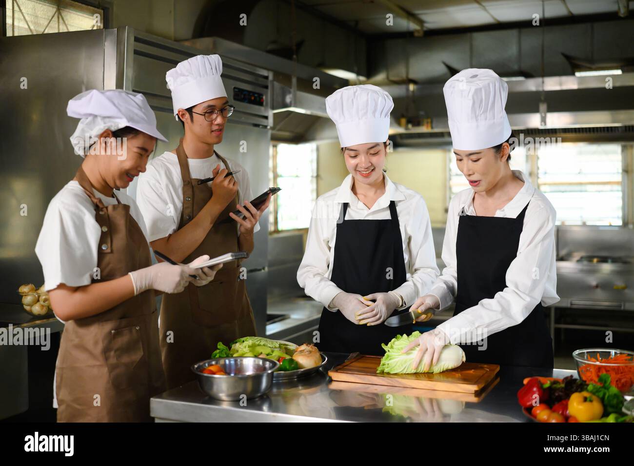 Cooking school teacher instructs students on vegetable cutting ...