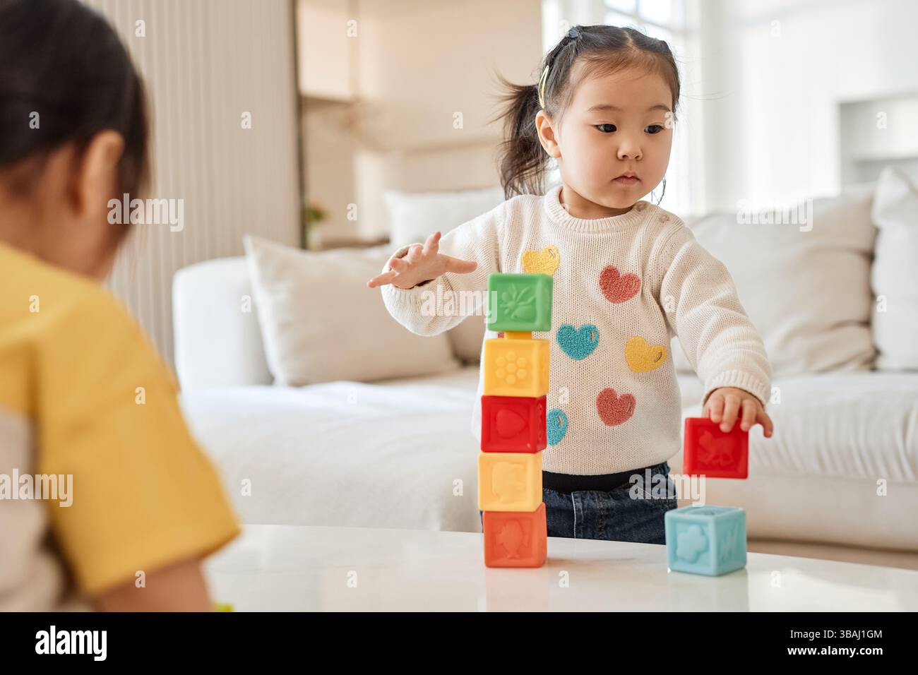 Asian little girl playing with colorful blocks in the living room at ...