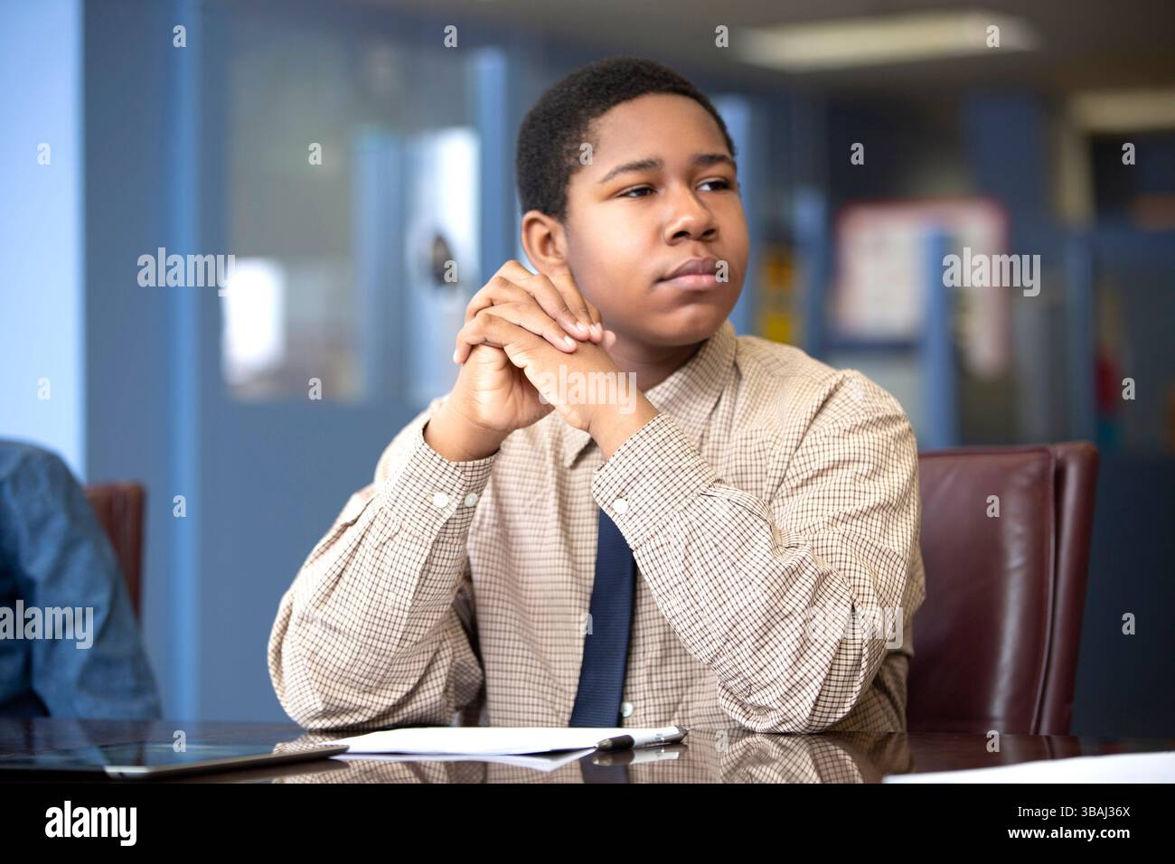 Young black boy sitting at desk paying attention in school classroom ...