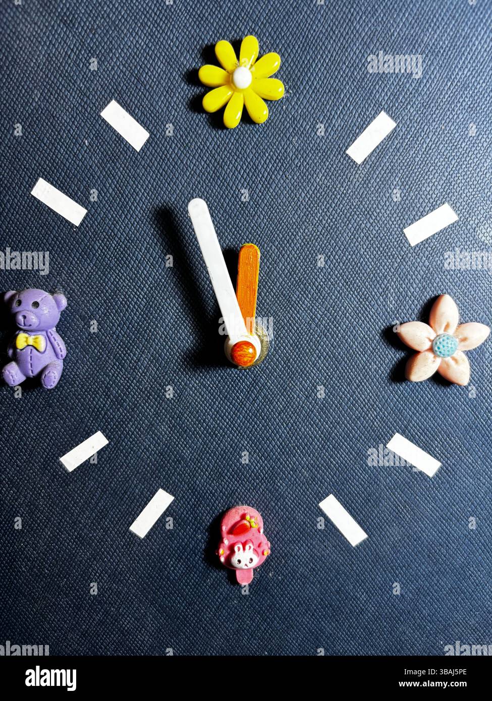 An adorable hand-made desktop standing clock with cute and colorful markers as the dial numerals. - Smartphone Captured Stock Image