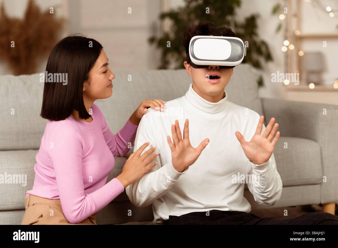 Millennial Couple Using Virtual Reality Glasses Playing Game At Home Stock Photo