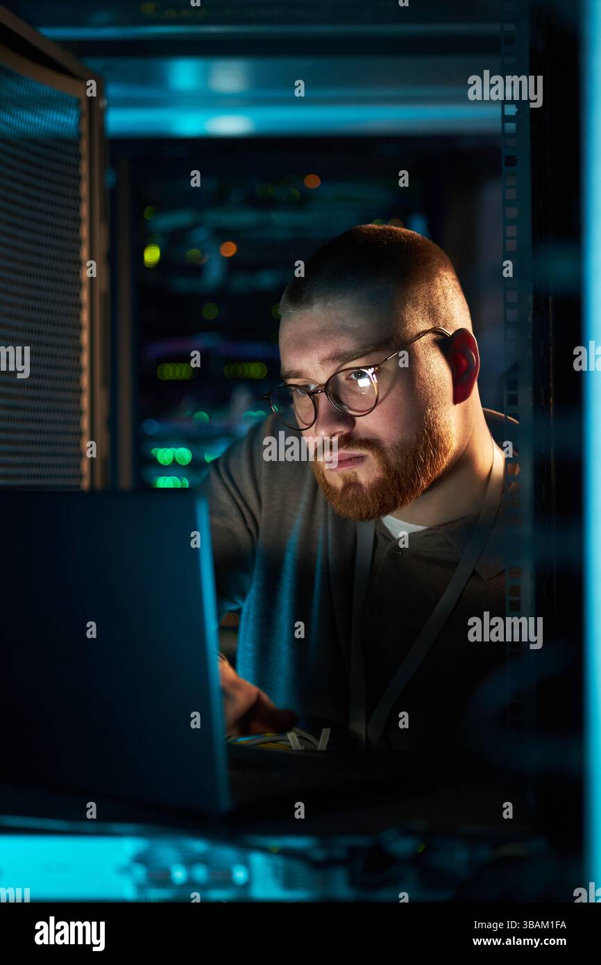 Working on Laptop in Data Center with Servers Stock Photo