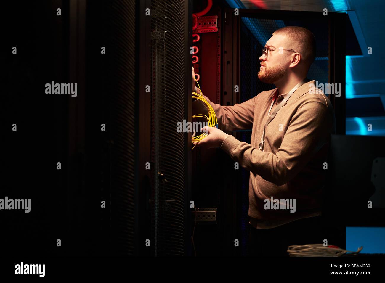 Technician Installing Network Cables in Server Room Stock Photo