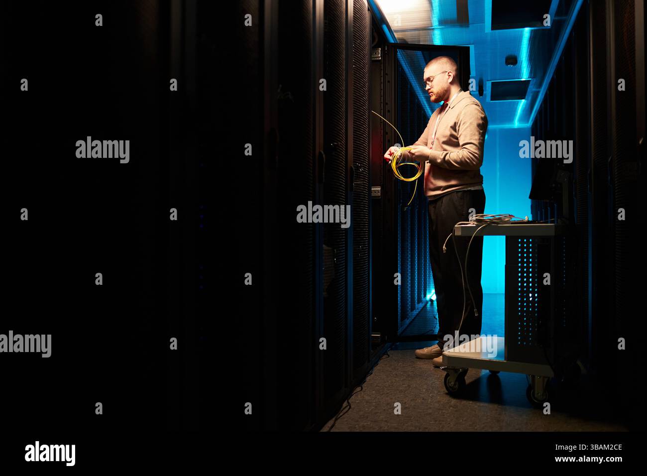 Technician Inspecting Server Racks in Data Center Stock Photo
