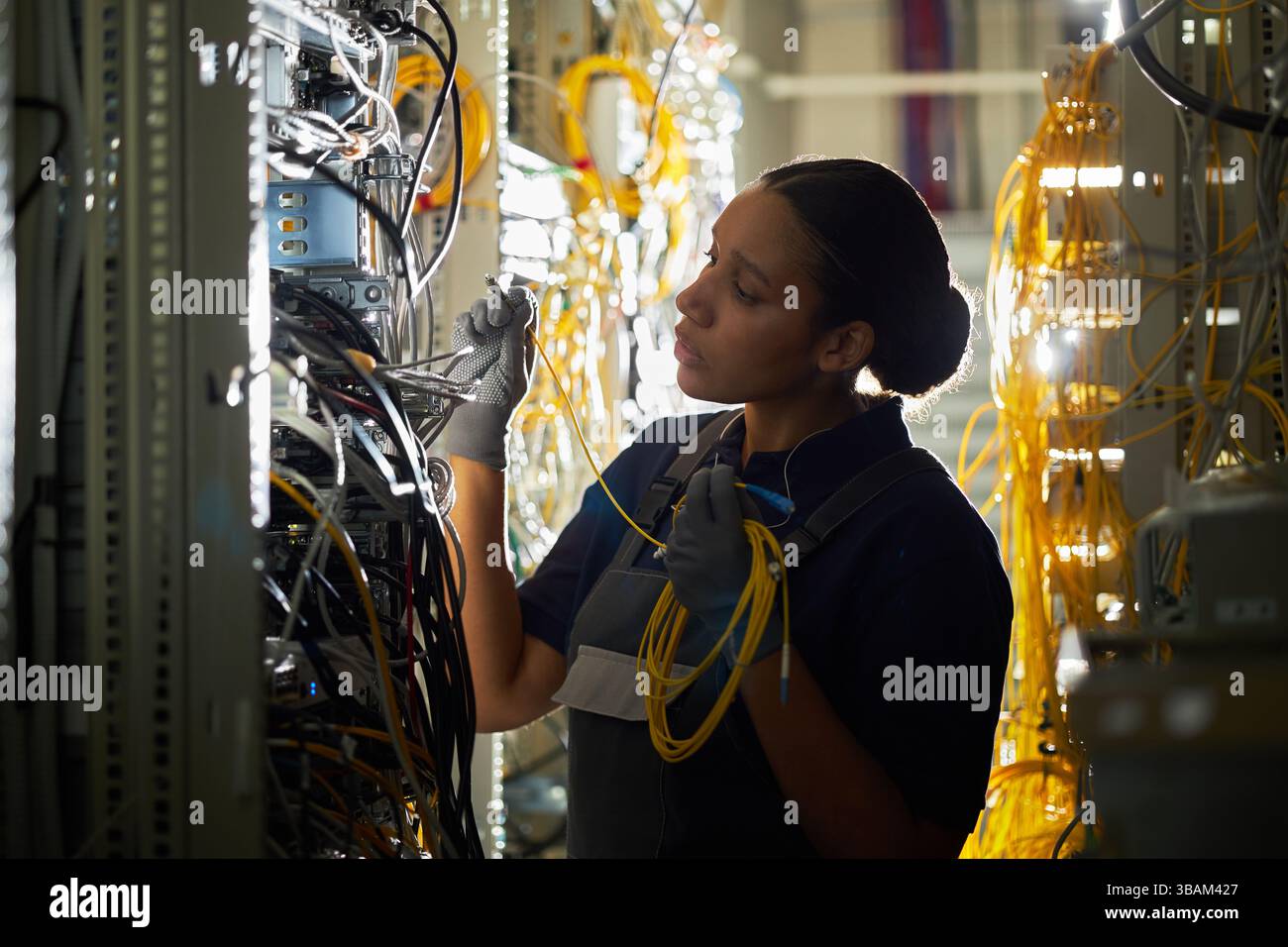 Technician Configuring Network Cables in Server Room Stock Photo