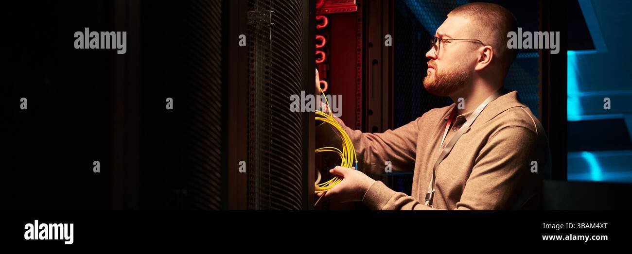 Technician Working in Data Center Fixing Network Cables Stock Photo