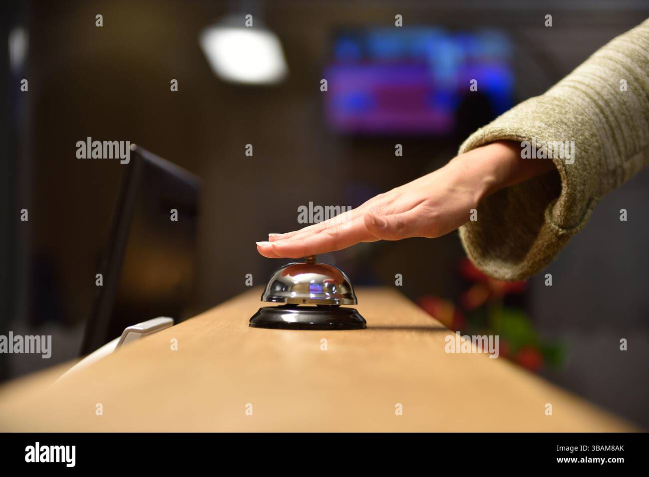 Hand of female guest ringing bell at reception desk in hotel Stock ...