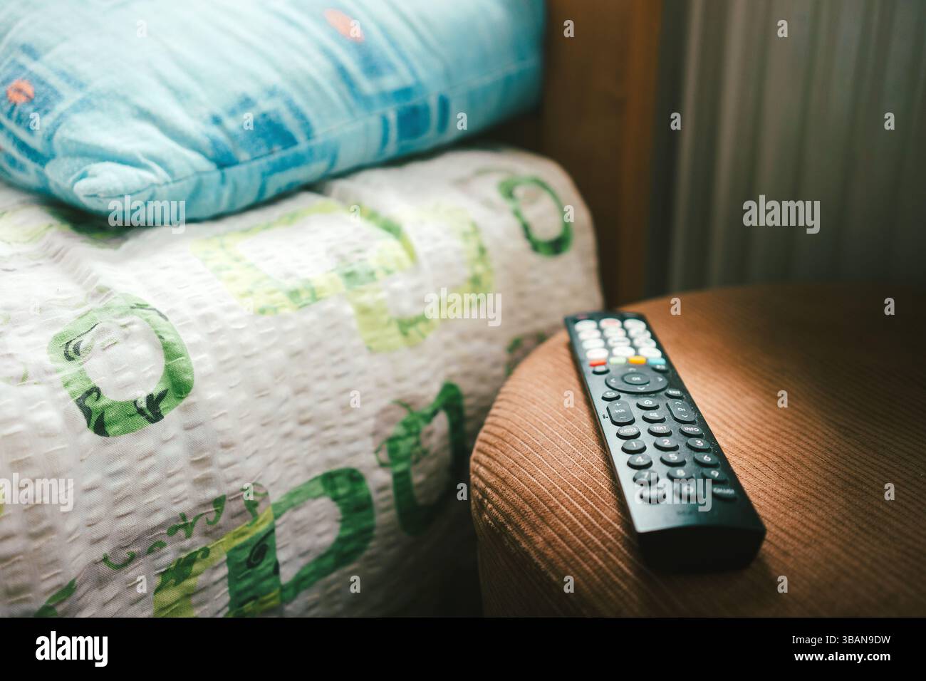 Remote control on the stool next to the bed in the room Stock Photo - Alamy