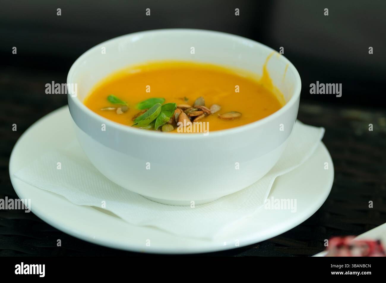 CreamVelvety pumpkin puree soup topped with roasted seeds and fresh greens. Elegant restaurant-style vegetarian dish full of autumn flavors.y pumpkin soup with seeds Stock Photo