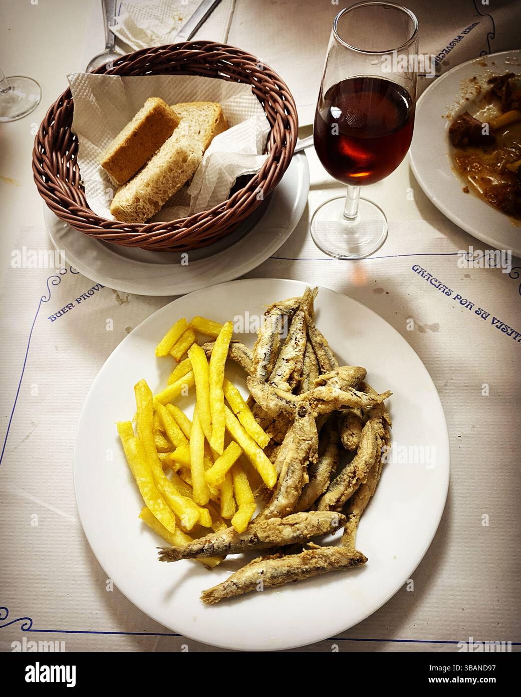 Fried boquerones fish with fried potatoes, bread and sherry sweet wine in Arcos de la Frontera, Cadiz province, Andalucia, Spain - Smartphone Captured Stock Image