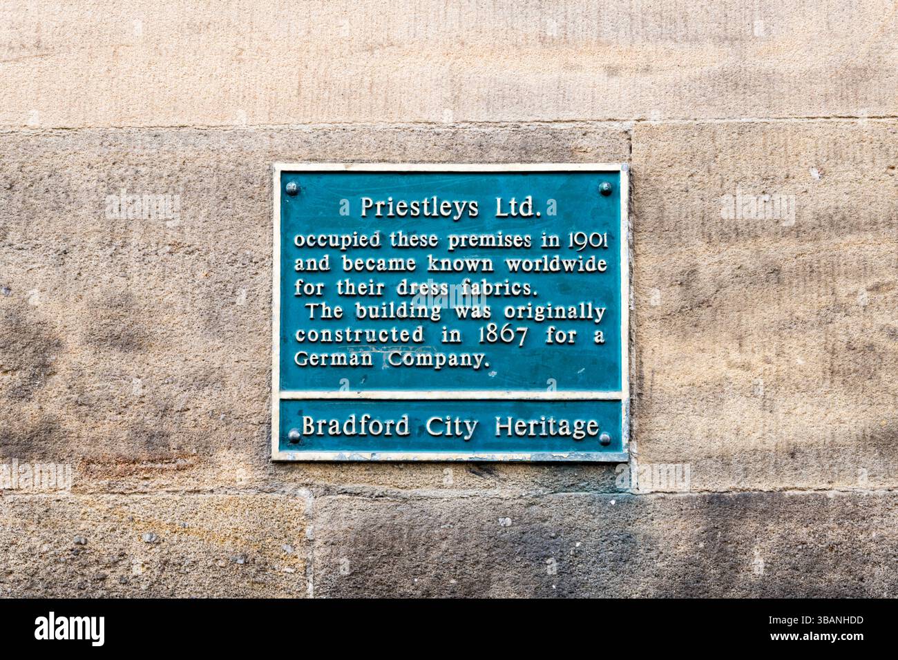 A green Bradford City Heritage plaque on the former premises of Priestleys Ltd in Little Germany, Bradford. Stock Photo