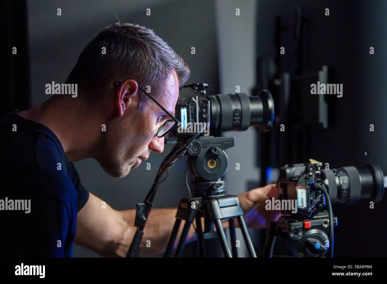 Hispanic male camera operator setting up camera during live broadcast ...