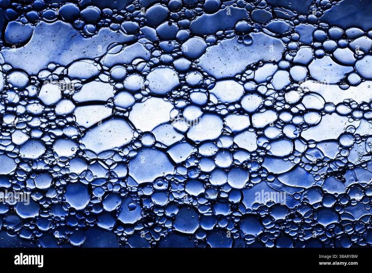 Closeup of abstract foam texture. Blue bubbles pattern with shiny gel effect. Clean surface with macro soap froth. Skincare and cosmetic concept. Stock Photo