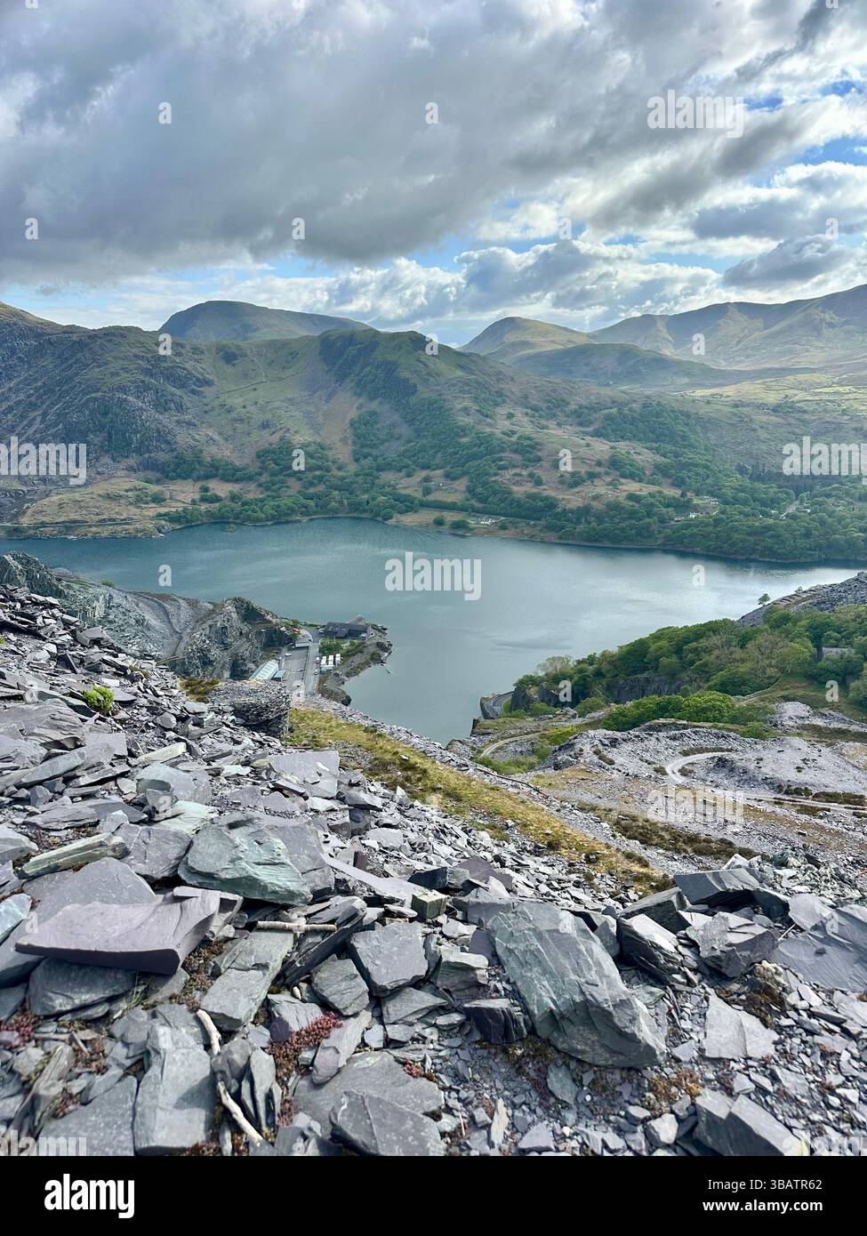Scenic elevated view from Dinorwic Quarry overlooking Llyn Paris with the dramatic mountain landscape of Snowdonia in the background. Bright day. - Smartphone Captured Stock Image