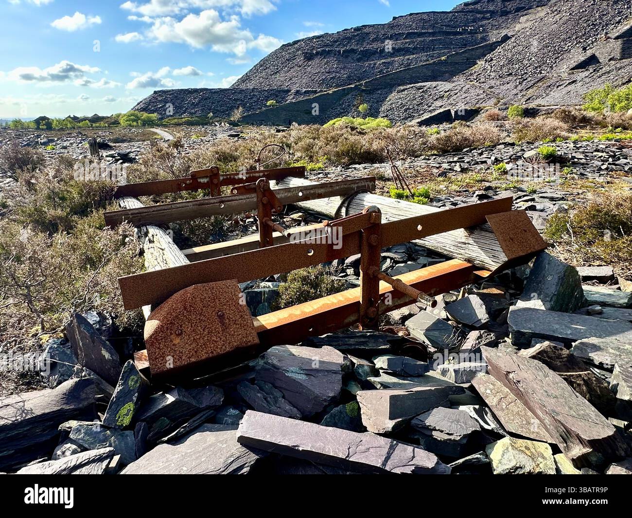 Abandoned wooden and rusted metal machinery at Dinorwic Quarry, Llanberis, Wales. Moss, grass, and slate hills in the background. No people. - Smartphone Captured Stock Image