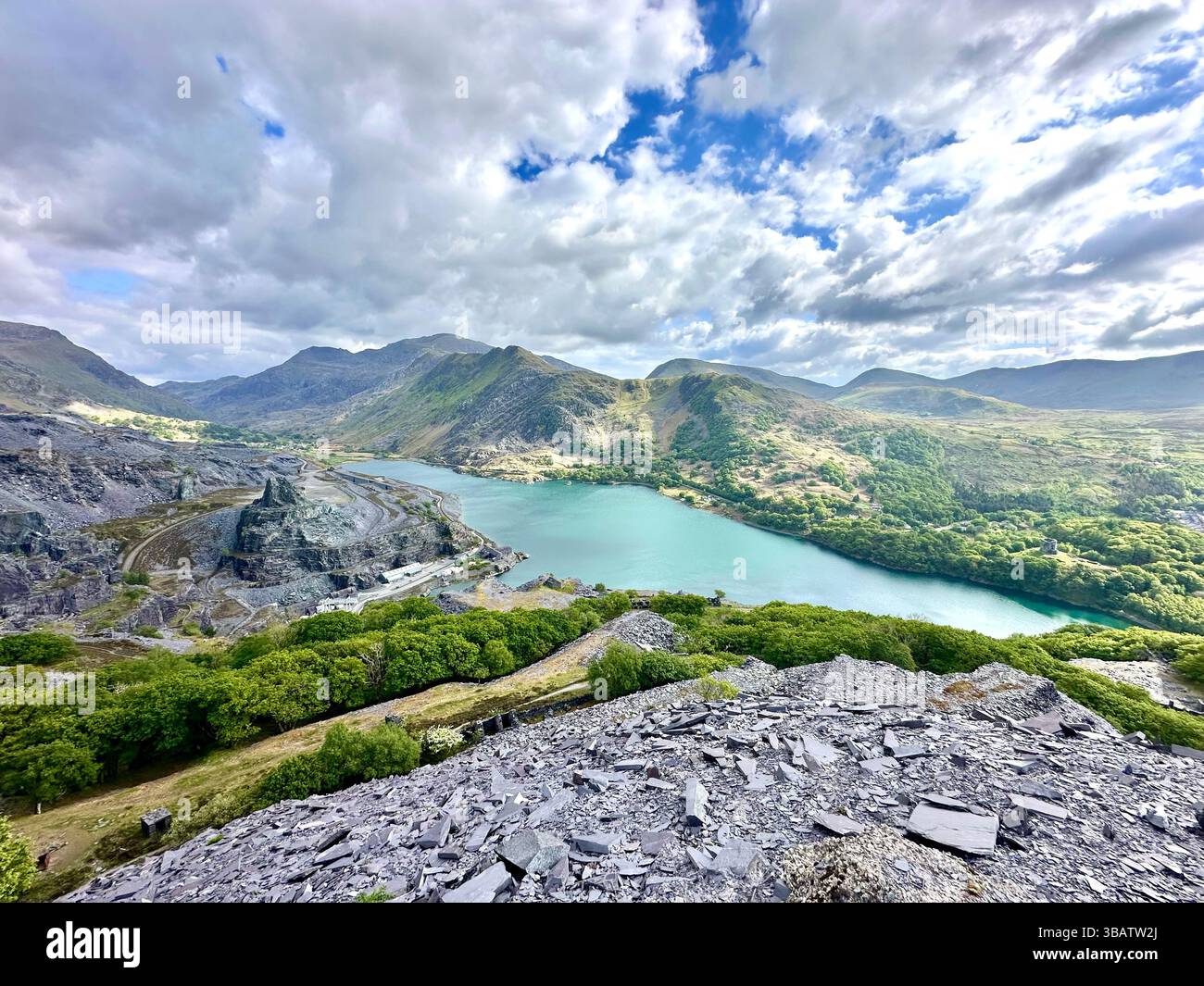 Scenic elevated view from Dinorwic Quarry overlooking Llyn Paris with the dramatic mountain landscape of Snowdonia in the background. Bright day. - Smartphone Captured Stock Image