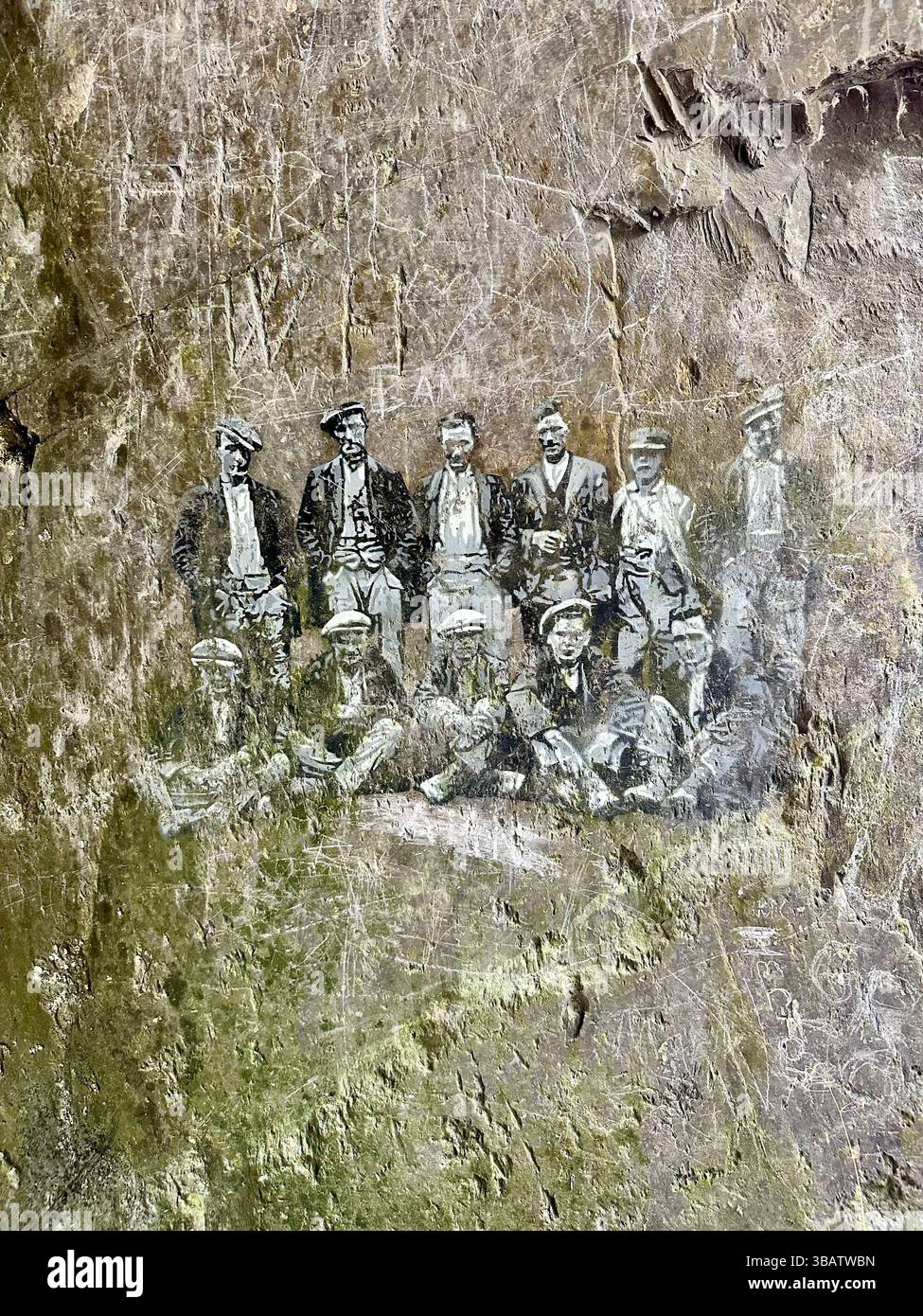 Slate wall with black and white drawings of quarry workers at Dinorwic quarry, Snowdonia, Wales, May 5, 2025. Historic site with hand drawn figures. - Smartphone Captured Stock Image