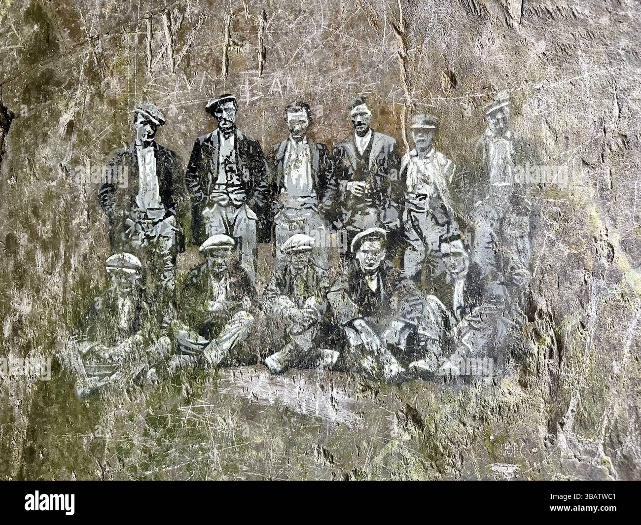 Slate wall with black and white drawings of quarry workers at Dinorwic quarry, Snowdonia, Wales, May 5, 2025. Historic site with hand drawn figures. - Smartphone Captured Stock Image