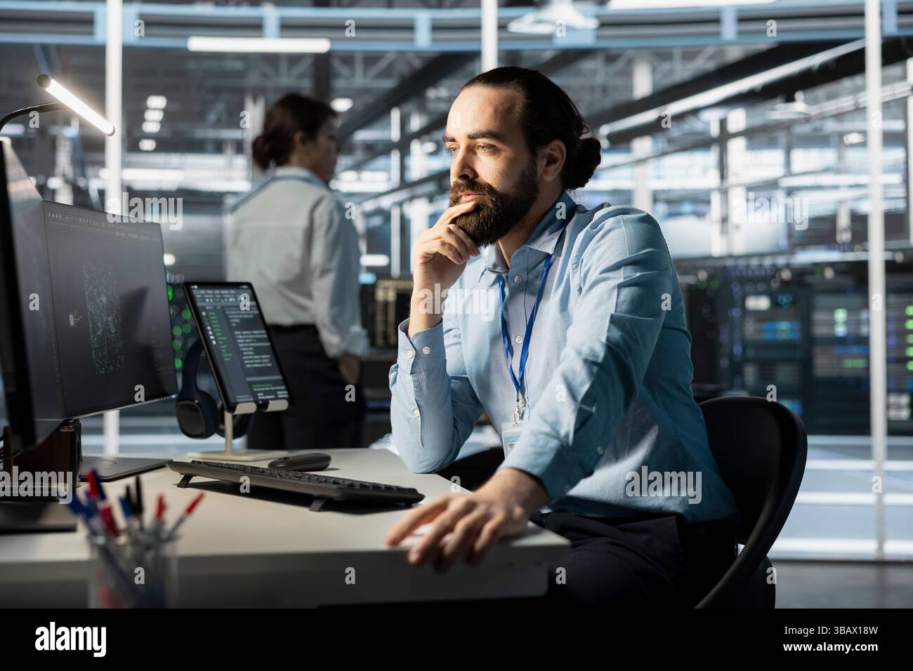 System administrator using computer in data center, managing server virtualization, running scripts. IT specialist using programming language on PC in server farm, finetuning network protocols Stock Photo