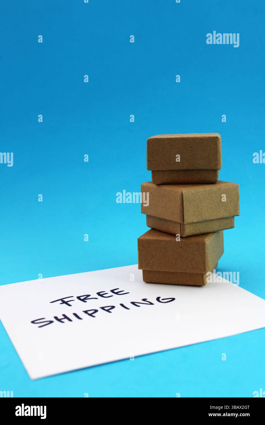 Free shipping phrase next to three delivered packages, cardboard boxes Stock Photo