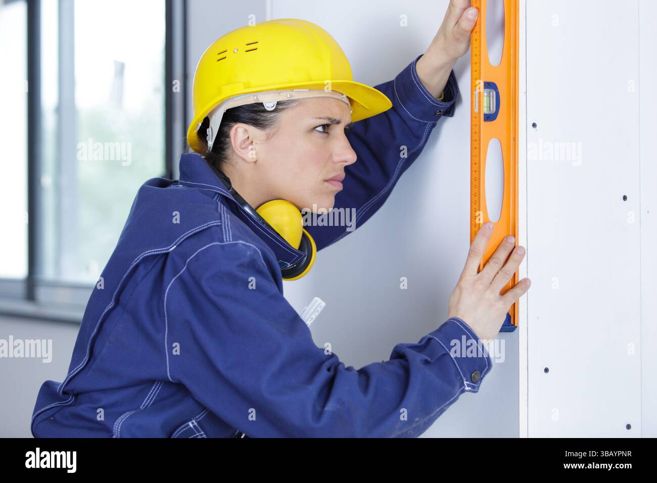 female builder using a spirit level Stock Photo