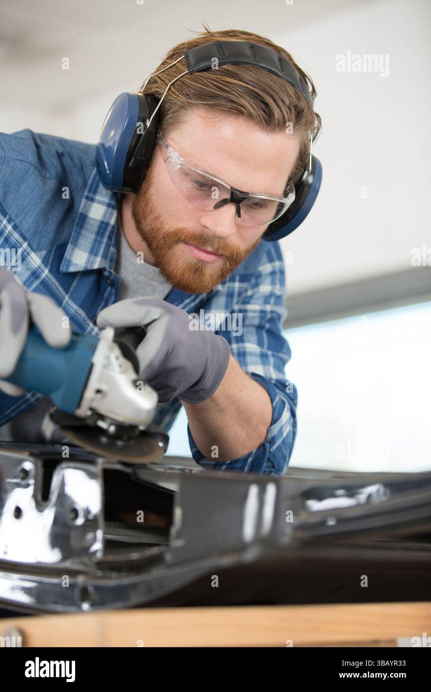 male mechanic using angle grinder Stock Photo