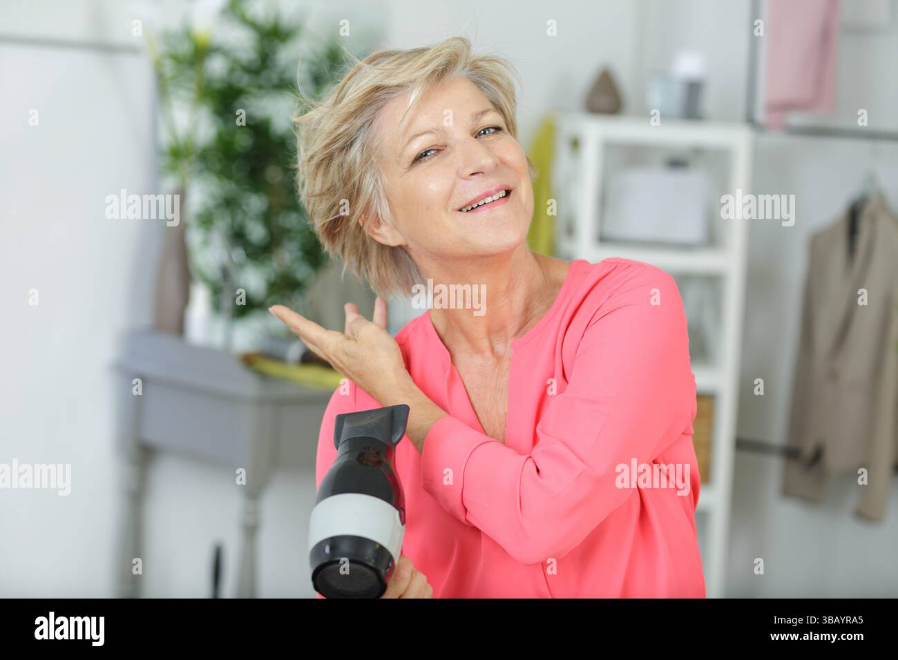Senior woman blow drying hair hi-res stock photography and images - Alamy