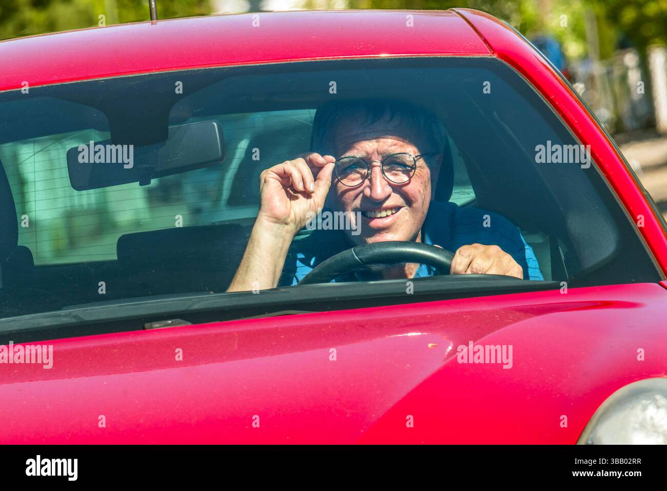 älterer Autofahrer von der Sonne geblendet, Symbolfoto, Sehprobleme, Mai 2025 Deutschland, München, Mai 2025, älterer Autofahrer, Ü60, am Steuer, Mann ist geblendet von der tiefstehenden Sonne, Symbolfoto, Brille tragen beim Autofahren, Sehstärke, Augenprobleme, Sehschwierigkeiten, Sicht, Blendung, blenden, Stress, Senioren, Unfallgefahr, Führerschein, Licht, Babyboomer, *** older driver blinded by the sun, symbol photo, vision problems, May 2025 Germany, Munich, May 2025, older driver, over 60, at the wheel, man is blinded by the low sun, symbol photo, wearing glasses while driving, eyesight, Stock Photo